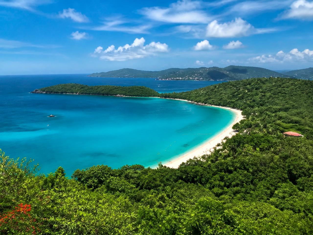 Overlook view of a turquoise bay and green hillsides in St. Thomas
